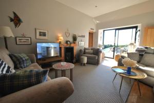 a living room with a couch and a tv at Mill View Cottage- charming coastal cottage in Saint Monance