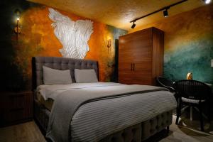a bedroom with a bed with a painting on the wall at Cappadocia Divin House in Goreme