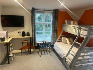 een slaapkamer met een stapelbed en een bureau met een computer bij CopperBeech Bed and Breakfast in Yoxford