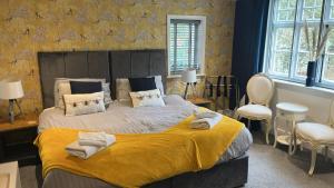 een slaapkamer met een groot bed met een gele deken bij CopperBeech Bed and Breakfast in Yoxford