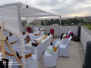 een groep witte tafels en stoelen onder een tent bij Atlantis City BnB in Nakuru +2 foto's