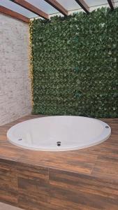 a white bath tub in front of a green wall at Oceano Residence in Búzios