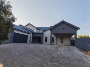 a house with a garage and a driveway at Tee Off House - Parys Golf and Country Estate in Parys