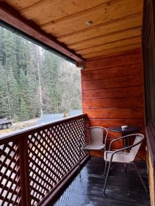 een veranda met 2 stoelen en een tafel. bij У Віти номер 4 in Synevyrsʼka Polyana