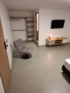 un soggiorno con sedia e TV di Hotel La Casona Estadio a Medellín Altre 51 foto