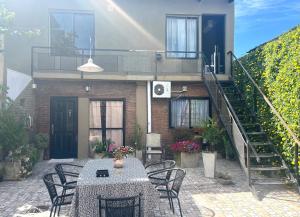 a house with a table and chairs and a staircase at Hospedaje Noah in Ezeiza
