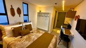 a bedroom with a bed and a desk in it at Hit Cabo Branco Flat Aconchego a 30 metros do mar in João Pessoa