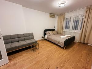 a living room with a bed and a couch at Astor Wellness apartman in Belgrade