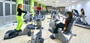 a gym with people exercising on cardio machines at Astor Wellness apartman in Belgrade