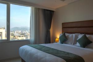 a hotel room with a bed and a large window at Hotel De Blossom in Guwahati