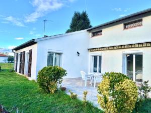 een wit huis met een tafel en stoelen bij " Au coin du Lys " Garage - Jardin - Wifi in Saint-Lys