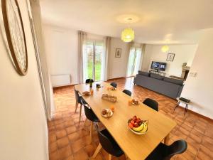 een eetkamer met een tafel met een fruitschaal erop bij " Au coin du Lys " Garage - Jardin - Wifi in Saint-Lys