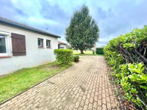 a brick driveway in front of a house at " Au coin du Lys " Garage - Jardin - Wifi in Saint-Lys