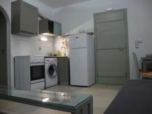 a kitchen with a refrigerator and a washing machine at Anima Apartments in Chora Folegandros