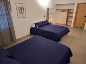 due letti in una stanza con lenzuola blu di Hotel La Casona Estadio a Medellín