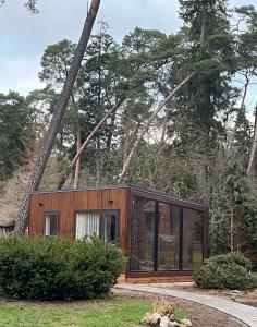Ein winziges Haus im Wald mit Glastüren in der Unterkunft Walnut house in Kulautuva
