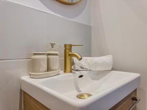 a bathroom with a sink with a gold faucet at Liberté Prestige - Tram - Rocade in Fontaine +51 photos