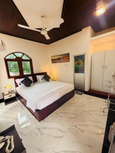 een slaapkamer met een bed en een plafondventilator bij New Star Villa in Bentota