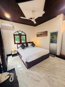 een slaapkamer met een bed en een plafondventilator bij New Star Villa in Bentota