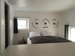 a bedroom with a bed and clocks on the wall at Le Dix-Huit Studio Duplex in Rouen
