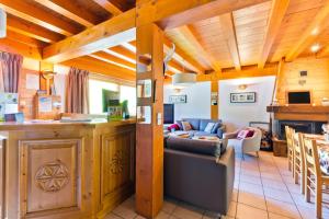a kitchen and living room with a couch and a table at Chalet Hôtel Aiguille Blanche Logis in Les Gets