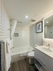 a bathroom with a tub and a toilet and a sink at Quality Inn & Suites Thunder Bay Downtown in Thunder Bay