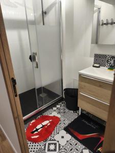 een badkamer met een douche en een rood tapijt op de vloer bij L'Antre Du Désir in Wierre-Effroy