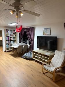 a living room with a television and a table and chairs at Mysigt boende med bastu och kamin in Strömstad