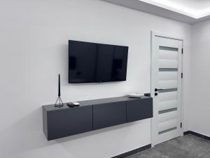 a living room with a tv on a white wall at Grey Serenity in Brăila