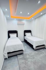 two beds in a room with white walls at Apartmarsala in Ovaköy