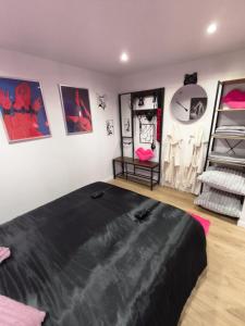 een slaapkamer met een groot zwart bed in een kamer bij L'Antre Du Désir in Wierre-Effroy