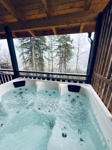 eine Whirlpool-Badewanne in einer Hütte mit Fenster in der Unterkunft Cabanes et Lodges du Belvedere in Serrières-sur-Ain