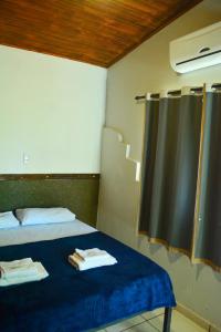 una camera con due letti e una finestra con asciugamani di RepousaAquiÓ Olímpia a Olímpia