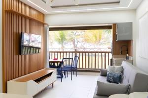 a living room with a couch and a balcony at Bungalow Frente Mar N 101 in Caucaia