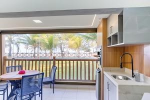 a kitchen with a table and chairs and a balcony at Bungalow Frente Mar N 101 in Caucaia