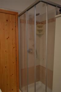 um chuveiro com uma porta de vidro na casa de banho em Appartamenti BUCANEVE em Madonna di Campiglio