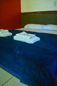 due letti con asciugamani sopra una coperta blu di RepousaAquiÓ Olímpia a Olímpia