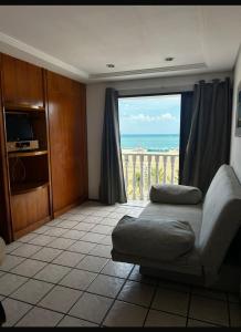 un soggiorno con un divano e una grande finestra di Classic Flat a Fortaleza