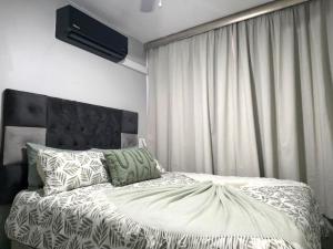 a bedroom with a bed with a white comforter at DURBAN BEACHFRONT Tenbury 903 in Durban +63 photos