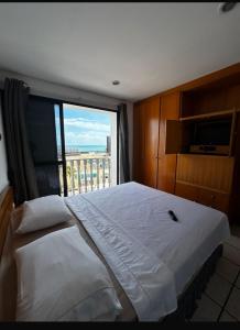 una camera da letto con un letto grande con una grande finestra di Classic Flat a Fortaleza