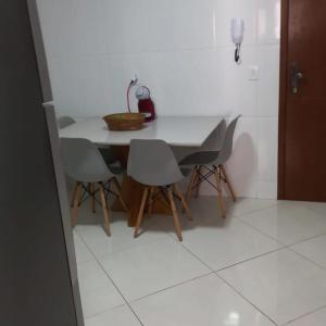 un tavolo e delle sedie in una stanza con il pavimento bianco di Apartamento Beira-mar a Guarapari 1 altra foto