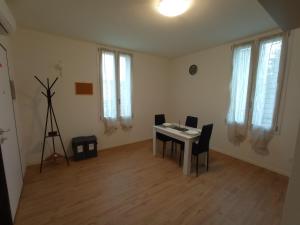 een witte kamer met een tafel, stoelen en ramen bij Hello Parma in Parma +15 foto's