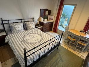 una camera da letto con un letto, una scrivania e una finestra di Auberge de la Croix du Pape a Èze Altre 23 foto