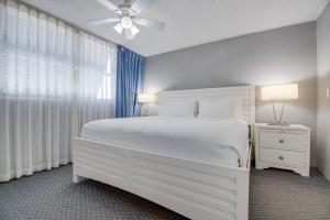 基韦斯特The Barbados - Sunrise Suites的一间卧室，有一张白色的床和一扇窗户 更多8张照片