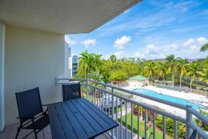 基韦斯特The Barbados - Sunrise Suites的享有游泳池和棕榈树景致的阳台