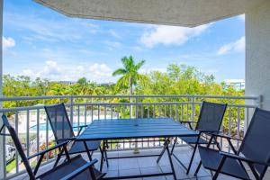 基韦斯特The Barbados - Sunrise Suites的阳台的天井配有蓝色的桌椅