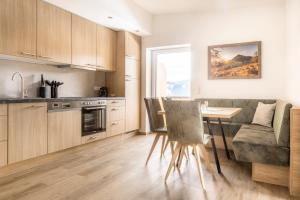 a kitchen with a table and chairs in a room at Peterlehen Appartements in Altenmarkt im Pongau