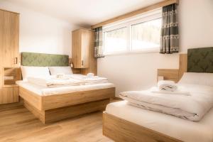 a room with two beds and a window at Peterlehen Appartements in Altenmarkt im Pongau