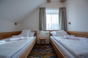two beds in a small room with a window at Apartmány Lúčny Raj in Ždiar +92 photos