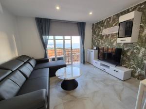 a living room with a black couch and a tv at Paraiso View Duplex Penthouse in Callao Salvaje +32 photos